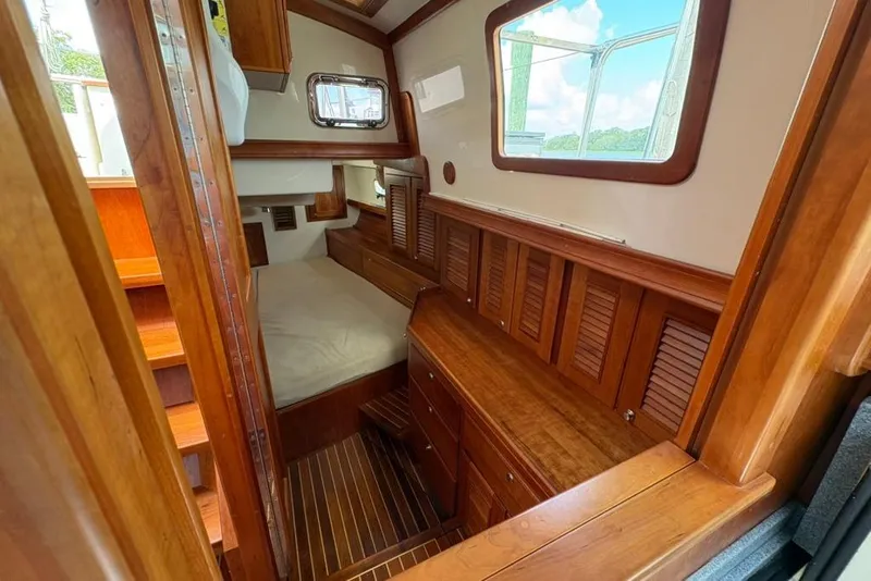 Slide: The Image of Interior of 2016 Gozzard 41 RC sailboat with wooden cabinetry and cozy sleeping area. - 17