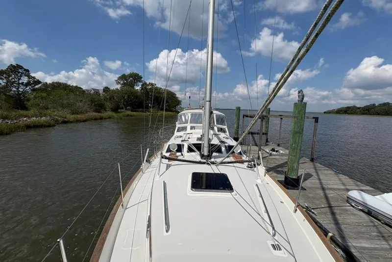 Slide: The Image of Sailboat Gozzard 41 RC (2016) docked by a scenic river under a blue sky. - 45