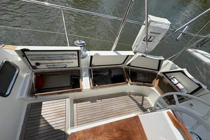 Slide: The Image of 2016 Gozzard 41 RC sailboat cockpit with open storage compartments and wooden flooring. - 37