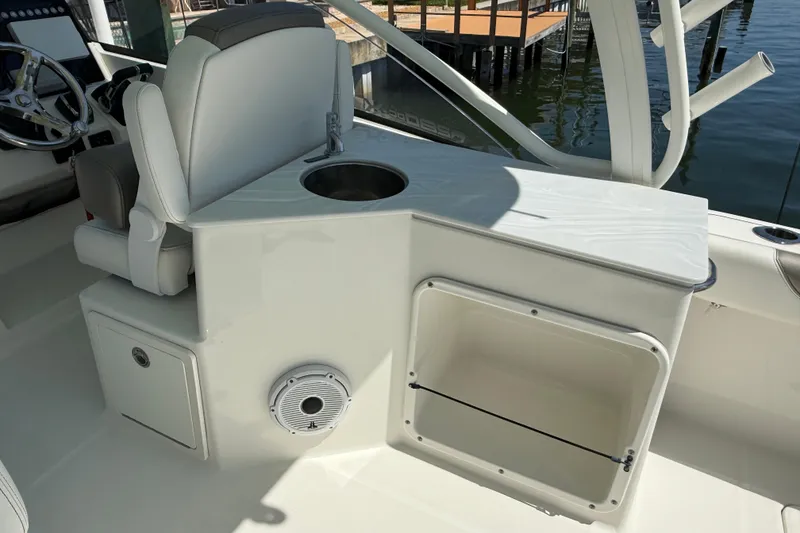 Slide: The Image of 2021 World Cat 280 DC-X boat interior with helm seat, sink, and storage compartment. - 14