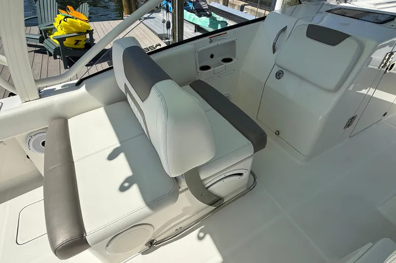 Slide: The Image of 2021 World Cat 280 DC-X boat interior with cushioned seating and storage compartments. - 9