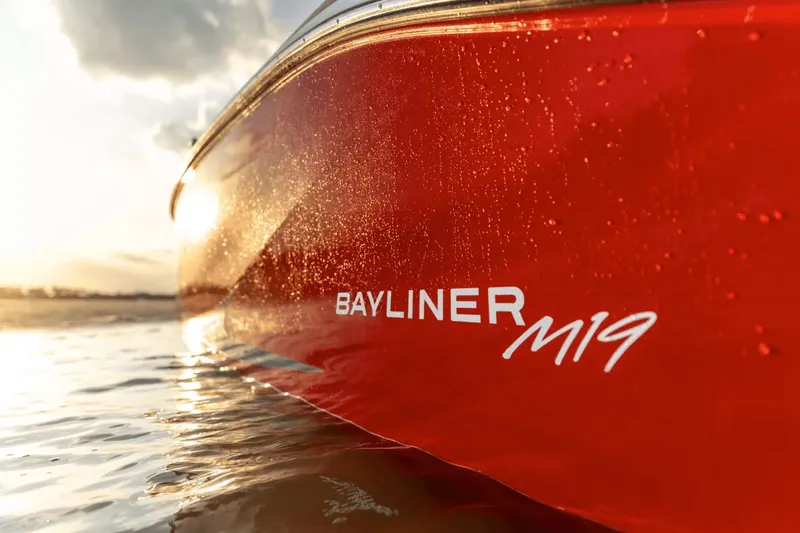 Slide: The Image of Red Bayliner M19 boat 2024 at sunset on water. - 6