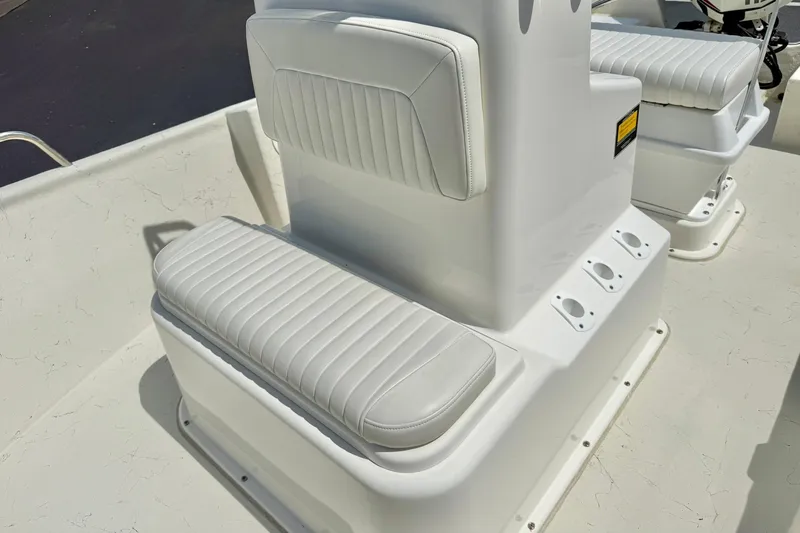 Slide: The Image of 2014 May-Craft 1800 Skiff boat interior with white cushioned seating and rod holders. - 18