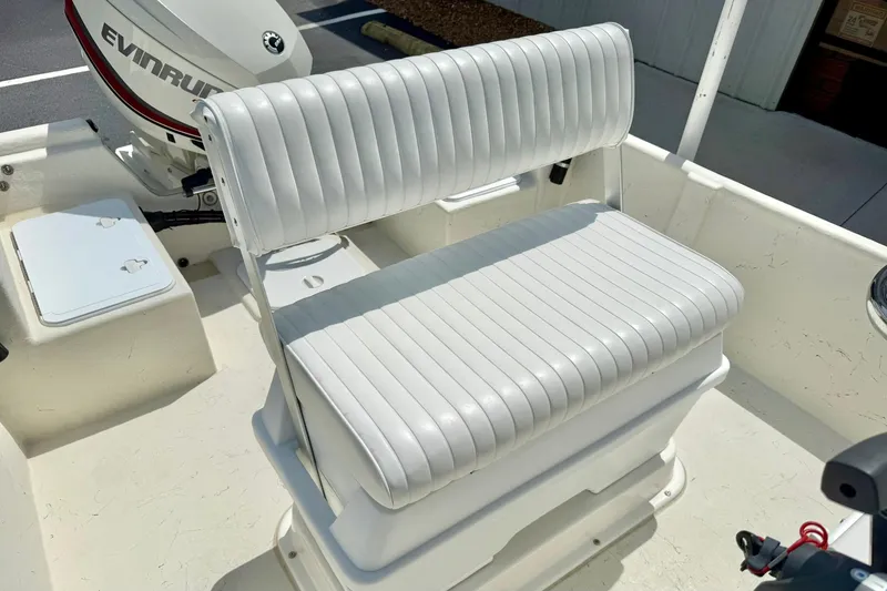 Slide: The Image of 2014 May-Craft 1800 Skiff boat interior with white cushioned seating and Evinrude motor. - 22