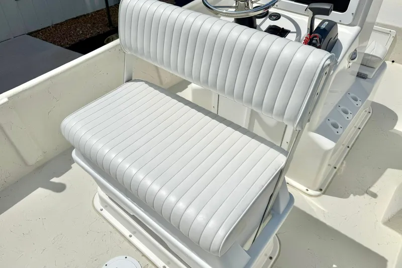 Slide: The Image of 2014 May-Craft 1800 Skiff boat interior with white cushioned seating and steering console. - 23