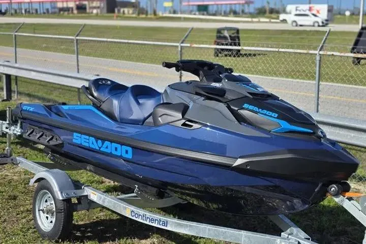 Slide: The Image of 2026 Sea-Doo GTX 230 jet ski on trailer, parked near a fence. - 8
