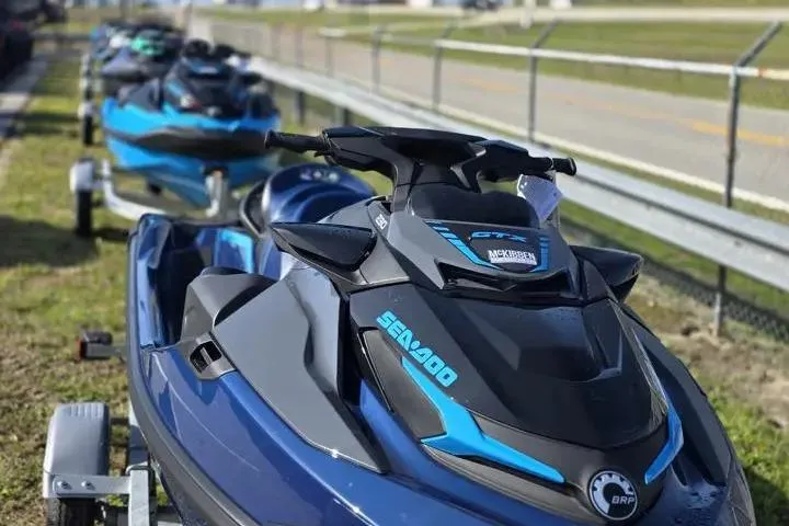 Slide: The Image of 2026 Sea-Doo GTX 230 jet skis lined up on trailers near a road. - 9