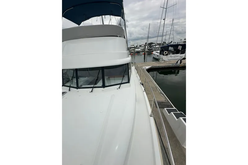 Slide: The Image of 2011 Beneteau Swift Trawler 34 Fly docked at marina, showcasing sleek design and flybridge. - 11