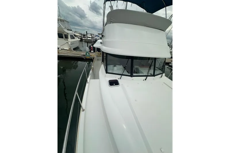 Slide: The Image of 2011 Beneteau Swift Trawler 34 Fly docked at marina, showcasing sleek design. - 12