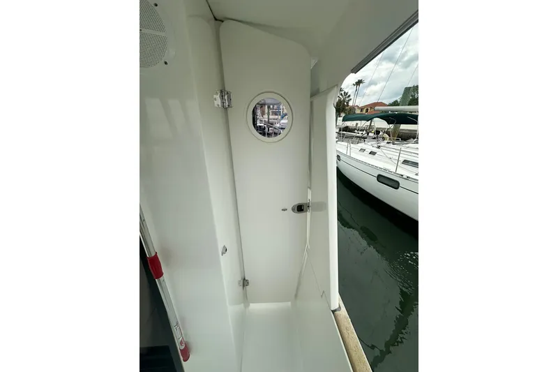 Slide: The Image of 2011 Beneteau Swift Trawler 34 Fly, exterior view with porthole and docked boats. - 19