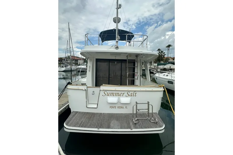 Slide: The Image of 2011 Beneteau Swift Trawler 34 Fly docked, rear view with "Summer Salt" name. - 2