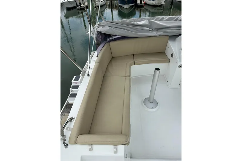 Slide: The Image of 2011 Beneteau Swift Trawler 34 Fly deck with beige seating and marina view. - 23