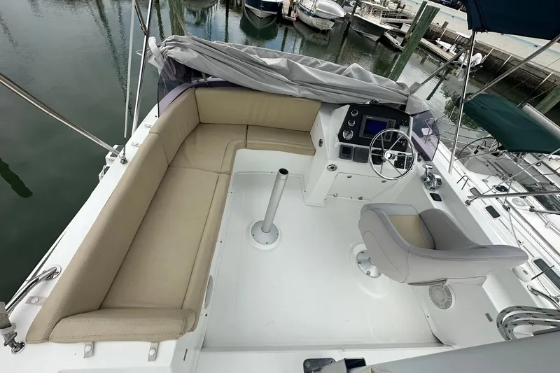 Slide: The Image of 2011 Beneteau Swift Trawler 34 Flybridge with beige seating and helm, docked at marina. - 24