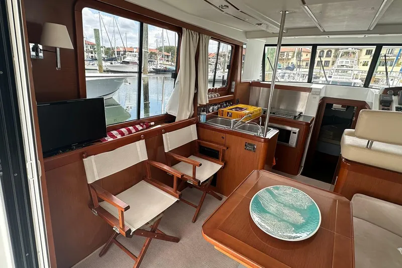 Slide: The Image of Interior of 2011 Beneteau Swift Trawler 34 Fly, featuring cozy seating and marina view. - 36