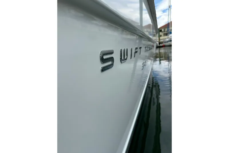 Slide: The Image of Side view of a 2011 Beneteau Swift Trawler 34 Fly, docked in a marina. - 4