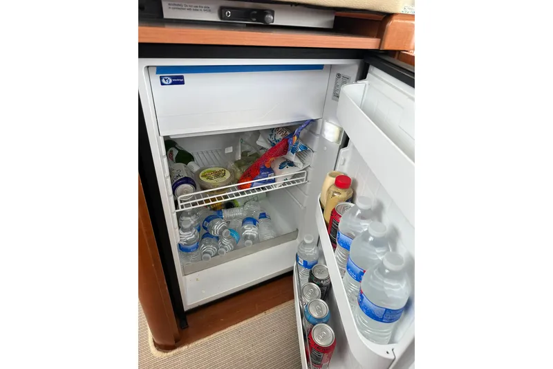 Slide: The Image of Mini fridge stocked with drinks and condiments on a 2011 Beneteau Swift Trawler 34 Fly. - 43