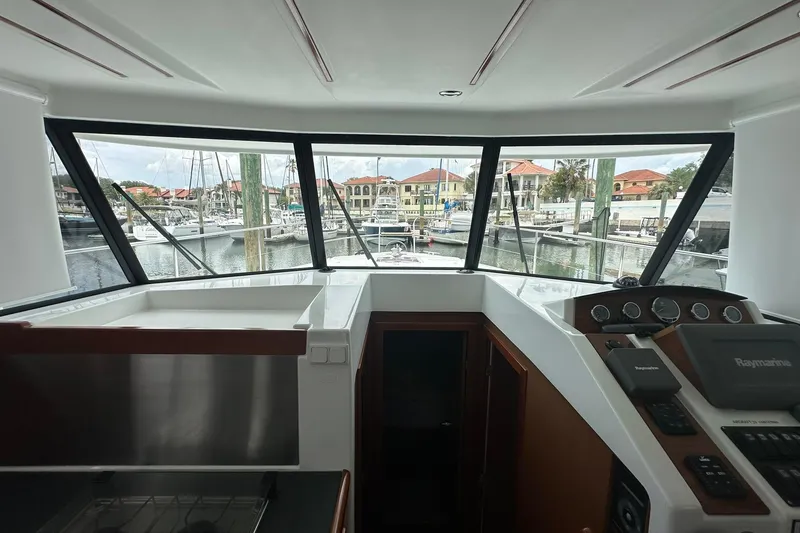 Slide: The Image of Interior view of 2011 Beneteau Swift Trawler 34 Fly, showcasing helm and marina backdrop. - 47