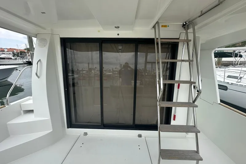 Slide: The Image of 2011 Beneteau Swift Trawler 34 Fly, rear deck with sliding glass doors and ladder. - 5