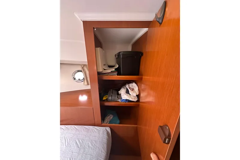 Slide: The Image of Wooden cabinet interior on 2011 Beneteau Swift Trawler 34 Fly, featuring shelves with stored items. - 59