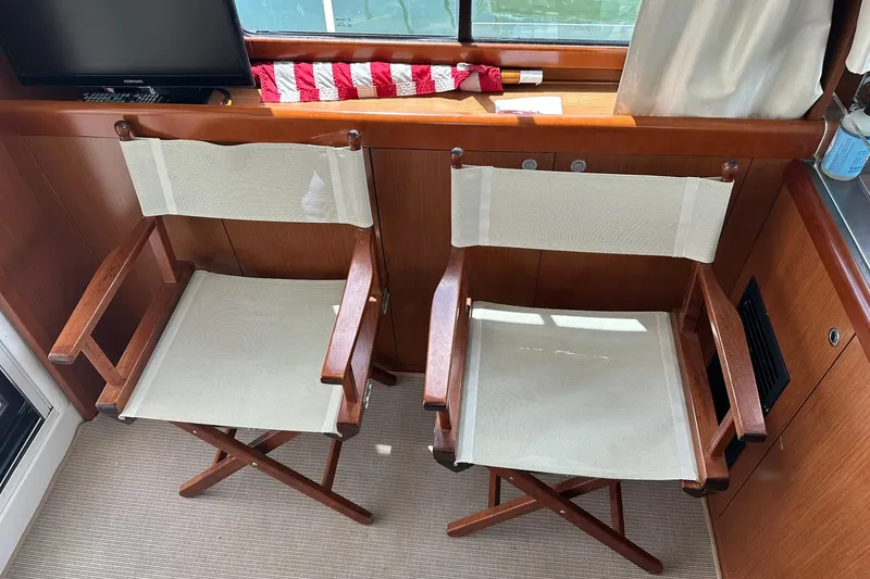 Slide: The Image of Two wooden director chairs inside a 2011 Beneteau Swift Trawler 34 Fly yacht. - 67
