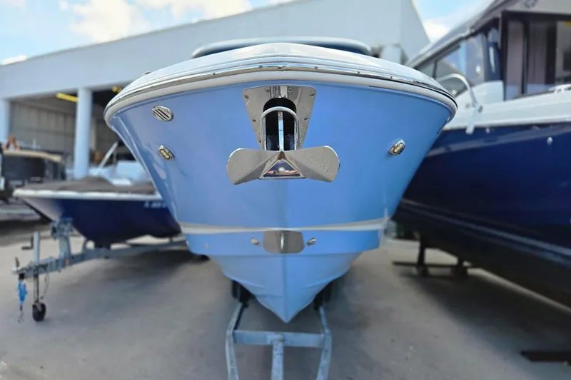 Slide: The Image of 2022 Chaparral 280 OSX boat, blue hull, displayed in a marina setting. - 21