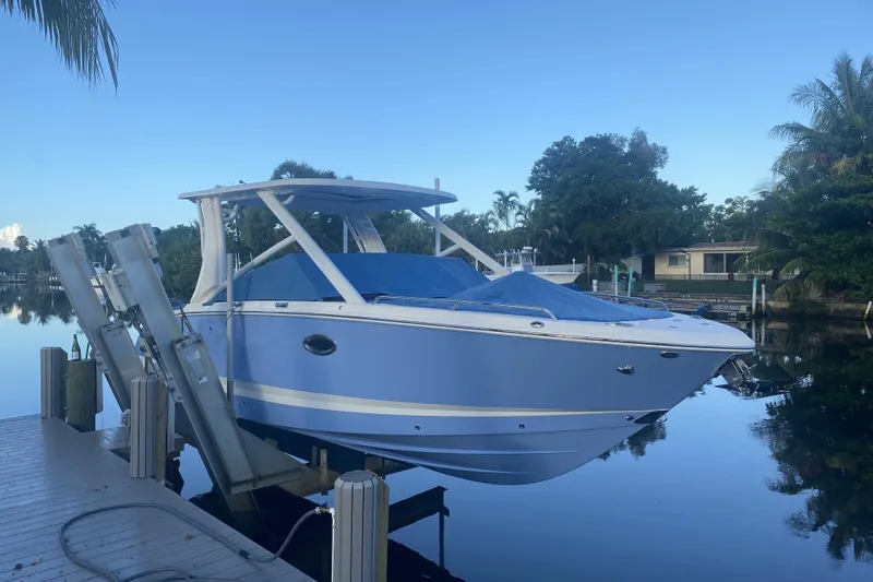 Slide: The Image of 2022 Chaparral 280 OSX boat docked on a serene waterfront. - 3