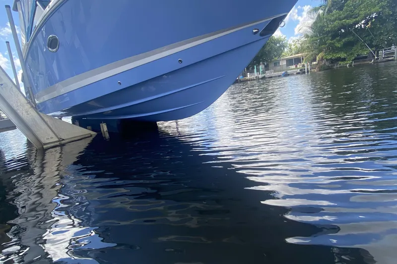 Slide: The Image of Blue 2022 Chaparral 280 OSX boat on lift over calm water. - 6