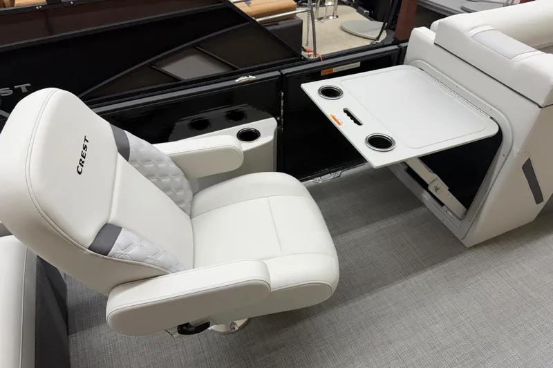 Slide: The Image of 2025 Crest Classic 240 boat interior with luxurious white seating and foldable table. - 7