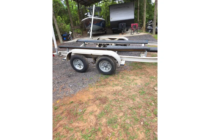 Slide: The Image of Boat trailer parked on gravel, with a 2002 Sea Chaser 2100 CC in the background. - 12