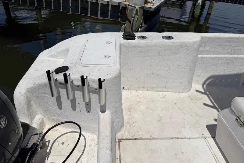 Slide: The Image of 2002 Sea Chaser 2100 CC boat interior with rod holders and storage compartments. - 19