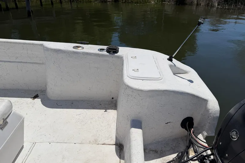 Slide: The Image of 2002 Sea Chaser 2100 CC boat interior with storage compartment and motor cables. - 20