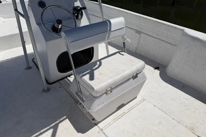 Slide: The Image of 2002 Sea Chaser 2100 CC boat interior with steering wheel and cushioned seat. - 21