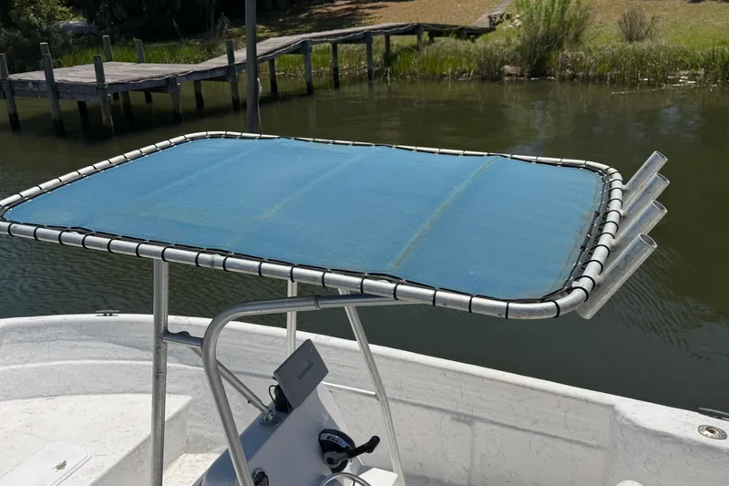 Slide: The Image of 2002 Sea Chaser 2100 CC boat with blue canopy, docked by a wooden pier. - 4