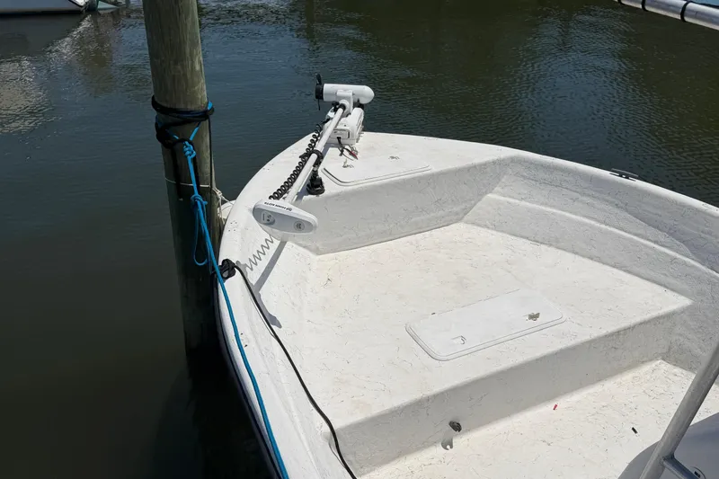 Slide: The Image of 2002 Sea Chaser 2100 CC boat docked, featuring a trolling motor and clean deck. - 9