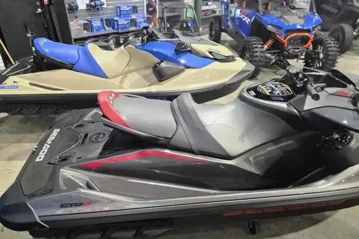 Slide: The Image of 2026 Sea-Doo GTR-X 300 jet ski displayed in a showroom with other vehicles. - 6