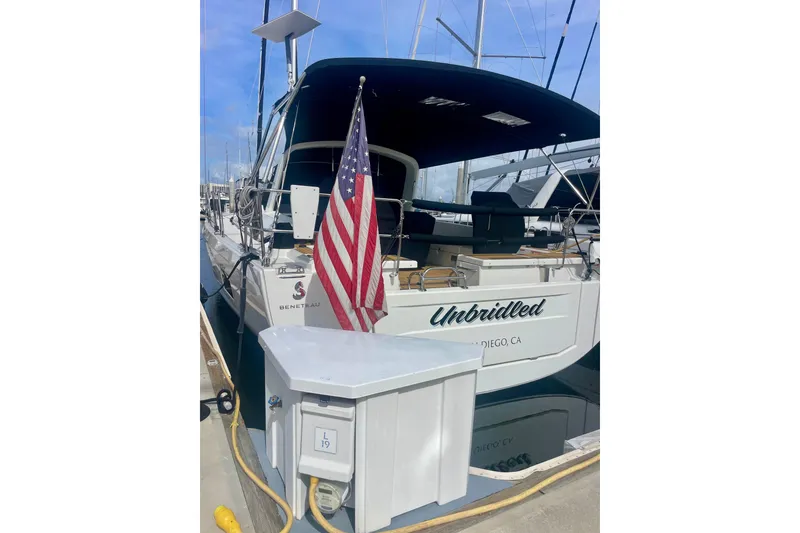 Slide: The Image of 2023 Beneteau Oceanis 51.1 yacht docked with American flag displayed. - 6