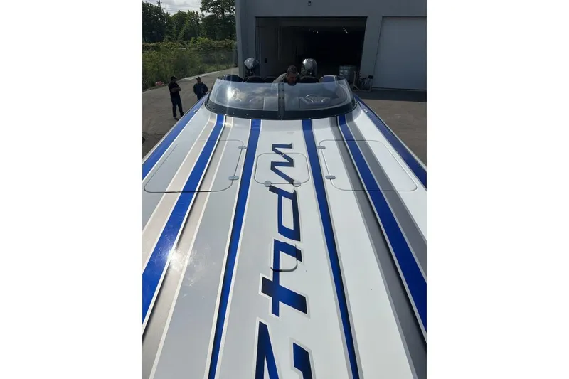 Slide: The Image of 2018 Wright Performance 420 boat with blue and white stripes, parked outside a garage. - 57