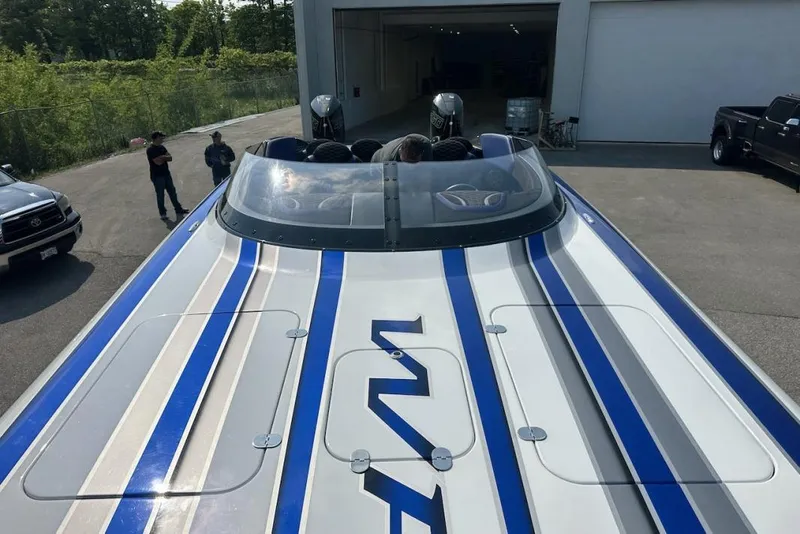 Slide: The Image of 2018 Wright Performance 420 boat with blue and gray stripes, parked outdoors. - 58