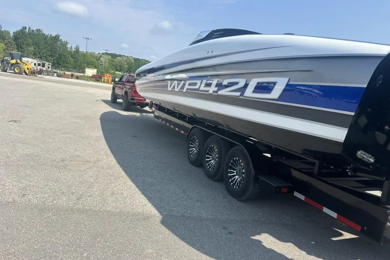 Slide: The Image of 2018 Wright Performance 420 boat on trailer, parked in a lot under a clear sky. - 66