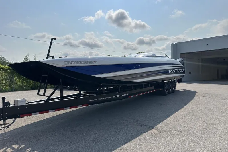 Slide: The Image of 2018 Wright Performance 420 boat on trailer, parked outside a garage under a cloudy sky. - 8