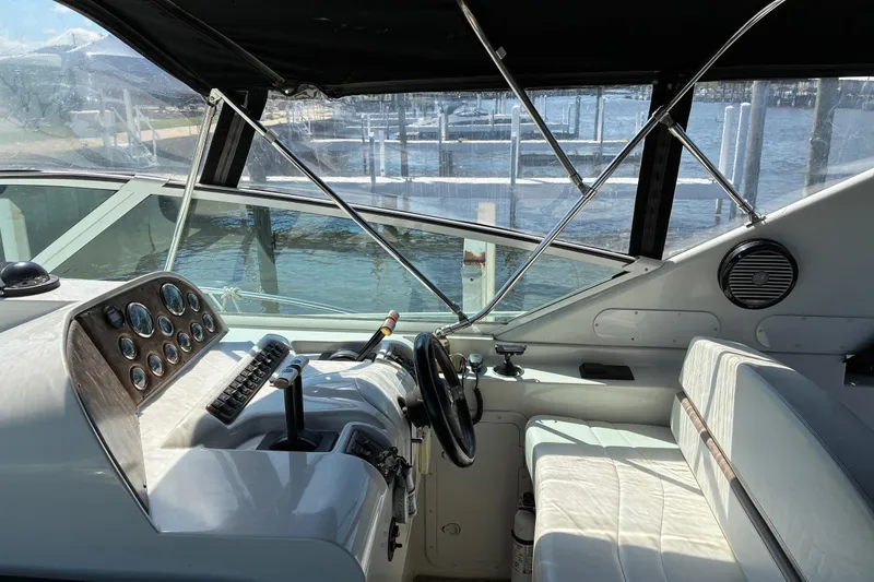 Slide: The Image of Interior view of a 1999 Trojan 360 Express boat cockpit with steering wheel and controls. - 10