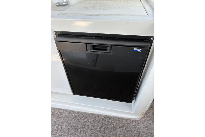 Slide: The Image of Black refrigerator on a 1999 Trojan 360 Express boat interior. - 14