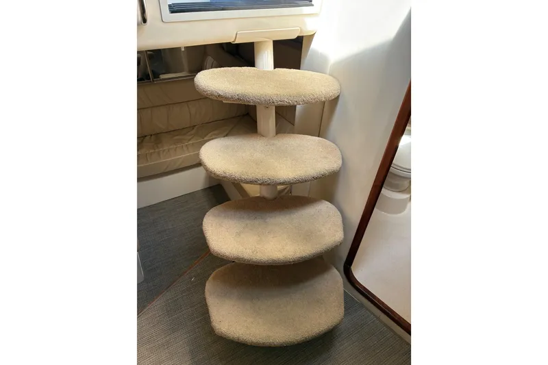 Slide: The Image of Carpeted steps inside a 1999 Trojan 360 Express boat interior. - 15