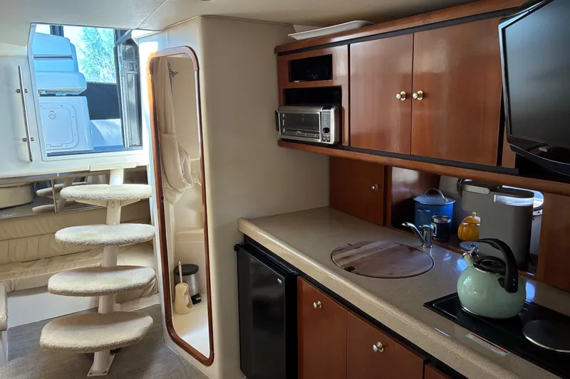 Slide: The Image of Interior of a 1999 Trojan 360 Express yacht with kitchenette and spiral stairs. - 16