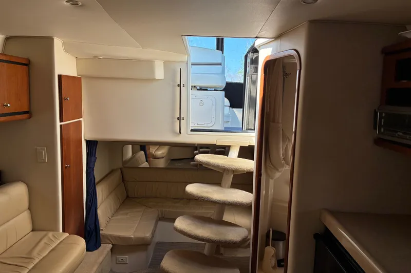 Slide: The Image of Interior of a 1999 Trojan 360 Express yacht with beige seating and carpeted stairs. - 18
