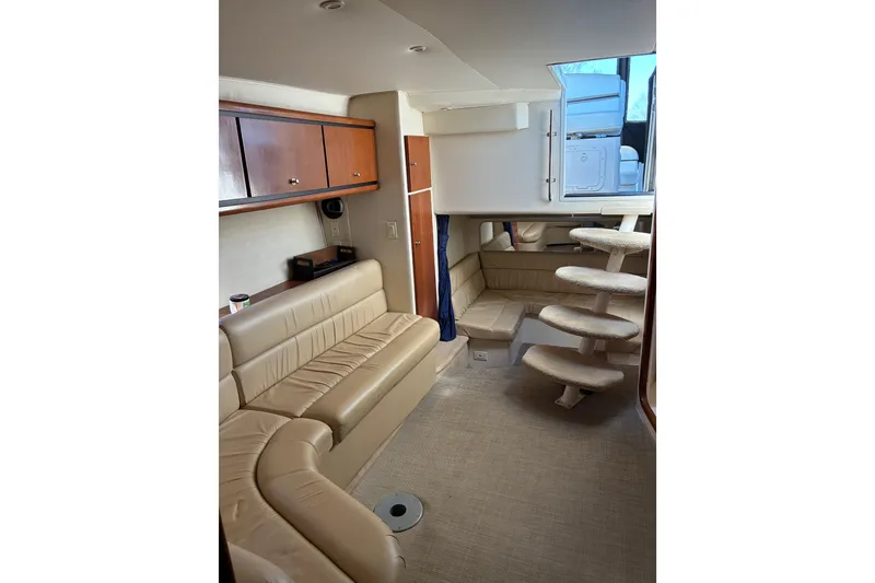 Slide: The Image of Interior of 1999 Trojan 360 Express yacht with beige seating and spiral staircase. - 19