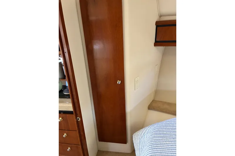 Slide: The Image of Interior of 1999 Trojan 360 Express yacht featuring wooden cabinetry and cozy sleeping area. - 25