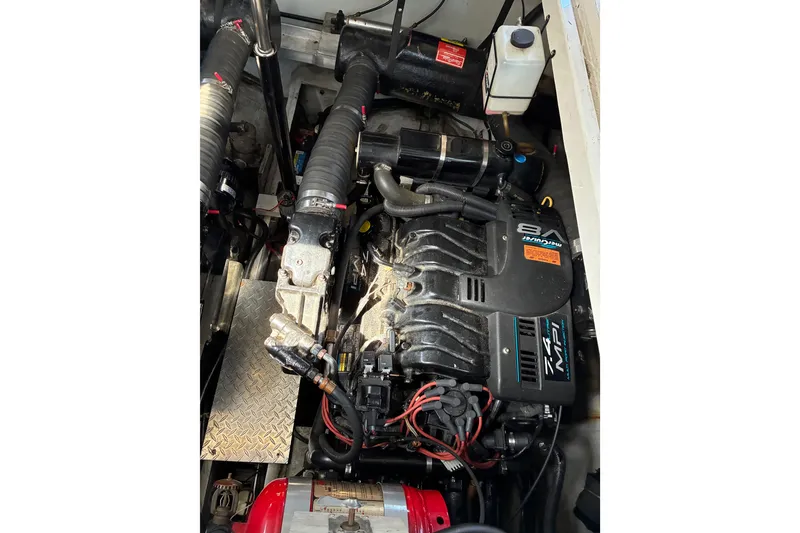 Slide: The Image of Engine compartment of a 1999 Trojan 360 Express boat, featuring a MerCruiser 7.4 MPI engine. - 27