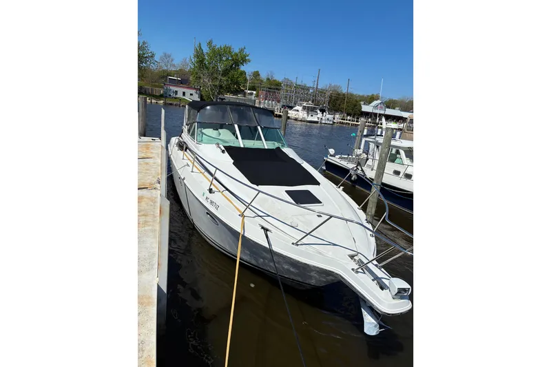 Slide: The Image of 1999 Trojan 360 Express boat docked at a marina on a sunny day. - 3
