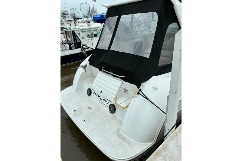 Slide: The Image of 1999 Trojan 360 Express yacht docked, featuring a covered rear deck and sleek design. - 4